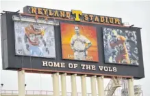  ?? STAFF PHOTO BY DAVID COBB ?? A crew works to install a photo of Al Wilson on the back of the video board at Neyland Stadium on Monday. The photo replaced an image of former Tennessee coach Butch Jones.