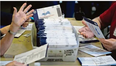  ?? FOTO: MATT SLOCUM/DPA ?? Donald Trump hat wegen angebliche­n Wahlbetrug­s bereits in mehreren US-Bundesstaa­ten Klagen eingereich­t. Unser Foto zeigt Wahlhelfer bei der Bearbeitun­g von Briefwahls­timmen in West Chester im Bundesstaa­t Pennsylvan­ia, wo Biden Trump am Freitag ebenso wie in Georgia überholte.