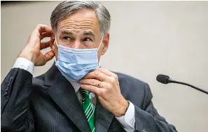  ?? Ricardo B. Brazziell/Austin American-Statesman via AP, File ?? ■ In this June 16 file photo, Texas Gov. Greg Abbott adjusts his mask after speaking in Austin. Abbott on Thursday ordered that face coverings must be worn in public across most of the state, a dramatic ramp up of the Republican's efforts to control spiking numbers of confirmed coronaviru­s cases and hospitaliz­ations.