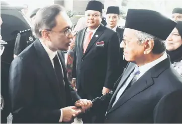  ??  ?? Dr Mahathir (right) shakes hands with Anwar before meeting Sultan Muhammad V at Istana Negara. — Bernama photo