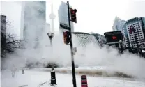  ?? TYLER ANDERSON/ POSTMEDIA NEWS ?? A pedestrian passes behind a cloud of steam this week in Toronto during a cold snap which has hit much of the country. The extreme temperatur­es have resulted in ‘ frost quakes.’