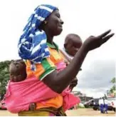  ??  ?? A woman dances with twin brothers during Twins Day celebratio­n in Abobo.