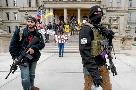  ?? AP ?? Armed demonstrat­ors protest coronaviru­s restrictio­ns imposed by Michigan Governor Gretchen Whitmer, outside the state capitol building in Lansing. A plot to kidnap Whitmer is not the first threat against state officials who have imposed business closures and curbs on social gatherings.