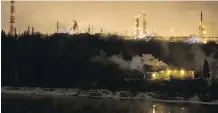  ?? IAN KUCERAK FILES ?? This week, Alberta oil and gas companies begin reporting fourth-quarter earnings from 2016. Here, Imperial Oil’s Strathcona Refinery in Edmonton and the North Saskatchew­an River are seen at night.