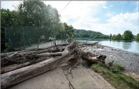  ?? NWA Democrat-Gazette/SPENCER TIREY ?? Wood and debris is piled up Friday on top of the dam and against the spillway at Lake Bella Vista.