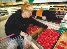  ??  ?? DES MONIES: In this March 23, 2011 file photo, a woman shops for tomatoes at a grocery store. — AP