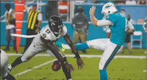  ?? The Associated Press ?? BLOCK PARTY: Baltimore’s Chris Matthews (13) blocks a punt by Miami’s Matt Darr in the first half of the visiting Ravens’ 31-7 victory in an exhibition game Thursday night.