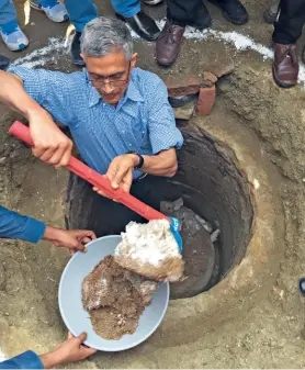  ??  ?? BREAKING TABOOS
Iyer emptying out decomposed waste to be used as organic compost from a toilet pit in Warangal