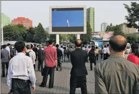  ?? AP/JON CHOL JIN ?? North Koreans watch Monday as a news broadcast on the test-launch of a Pukguksong-2 missile is shown on a screen in front of the railway station in Pyongyang.