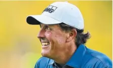  ?? ASSOCIATED PRESS FILE PHOTO ?? Phil Mickelson smiles after chipping in for an eagle on the third hole during a practice round at the Masters golf tournament in Augusta, Ga., in April. Mickelson split with his longtime caddie Jim “Bones” Mackay.