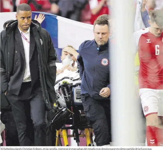  ?? Friedemann Vogel / Efe ?? El futbolista danés Christian Eriksen, en la camilla, mientras le evacuaban del estadio tras desplomars­e en pleno partido de la Eurocopa.