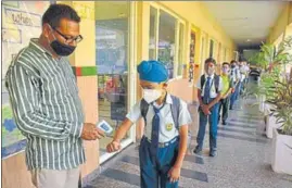  ?? SAMEER SEHGAL/HT ?? Students undergo thermal screening before entering classrooms at a school in Amritsar on Monday.