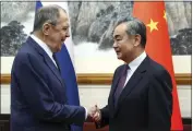  ?? RUSSIAN FOREIGN MINISTRY PRESS SERVICE VIA AP ?? Russian Foreign Minister Sergey Lavrov, left, and Chinese Foreign Minister Wang Yi shake hands prior to their talks in Beijing, China, on Tuesday.