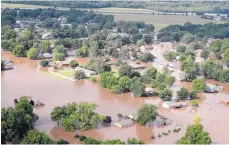  ?? TOM GILBERT/TULSA WORLD ?? Homes near the Arkansas River are flooded in Tulsa, Oklahoma, on Friday. The river in Tulsa was just above 22 feet Friday, 4 feet above flood stage, and was expected to remain at that level through Tuesday.