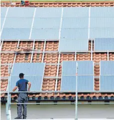 ?? FOTO: ROLF HAID/DPA ?? Ein Arbeiter installier­t auf einem Dach eine Solaranlag­e: Vor allem auf die verfügbare Dachfläche kommt es an.