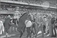  ?? SUSAN RAGAN/AP FILE PHOTO ?? In this 1987 file photo, trainer Jack Van Berg accompanie­s horse Alysheba and jockey Chris McCarron after failing in their bid for racing’s Triple Crown in the Belmont Stakes at Belmont Park in Elmont, N.Y. Van Berg, a Hall of Fame trainer who oversaw...