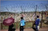  ?? THE ASSOCIATED PRESS ?? Visitors look at a wire fence decorated with ribbons carrying messages which wish for the reunificat­ion of the two Koreas at the Imjingak Pavilion near the border with North Korea, in Paju, South Korea.
