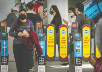  ?? ARLEN REDEKOP ?? Commuters pass through the Broadway SkyTrain and bus station on Monday as mandatory mask rules came into effect on all TransLink vehicles.