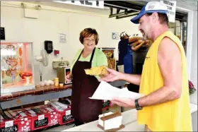  ?? HAROLD HOCH - FOR MEDIANEWS GROUP ?? Michelle Greer, who manages the pretzels and nachos stand, serves Billy Krall of Oley Township.
