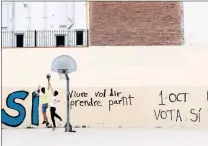 ??  ?? Young people play basketball in front of pro-independen­ce graffiti, three days after a banned independen­ce referendum in Barcelona. PICTURE: REUTERS