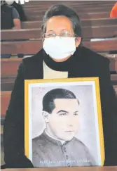  ??  ?? Una fiel de la comunidad sostiene una de las imágenes del padre Julio César Duarte Ortellado.