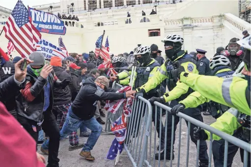  ?? JOHN MINCHILLO/AP ?? TOP: Supporters of President Donald Trump try to break through a police barrier Wednesday at the Capitol.