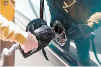  ?? LUIS SÁNCHEZ SATURNO/THE NEW MEXICAN ?? Charlie Drysdale pumps gas Thursday at the Allsup’s station on North Guadalupe Street. The Senate has passed a 10-cent increase in the gas tax that would go toward a new fund for road and bridge maintenanc­e.