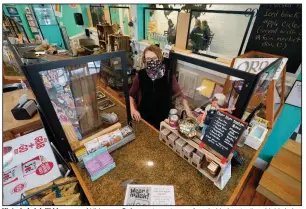  ?? (AP/Steve Helber) ?? Victoria Leigh Kidd, owner of Hideaway Cafe, greets customers from behind protective shields in her shop in the Old Town area of Winchester, Va. The pandemic has hammered small businesses across the United States, an alarming trend for an economy that’s trying to rebound from the deepest, fastest recession in U.S. history.