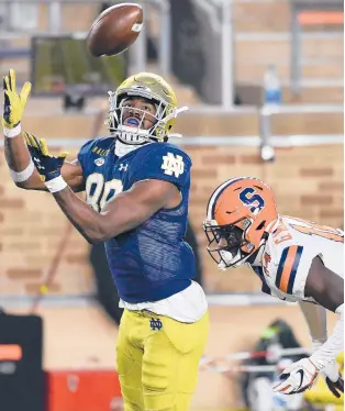  ?? MATT CASHORE/AP ?? ABOVE: Notre Dame wide receiver Javon McKinley catches a pass for a touchdown in front of Syracuse cornerback Garett Williams (14) in the second half Saturday In South Bend, Ind.