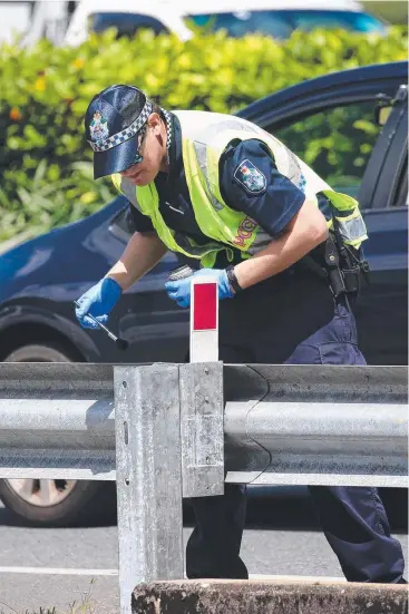  ?? Picture: STEWART McLEAN ?? INVESTIGAT­ION: Forensic police at work near Stockland shopping centre where a woman suffered serious injuries after falling into a large drain on Mulgrave Rd.