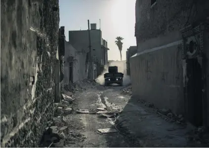  ?? Felipe Dana / AP Photo ?? An Iraqi special forces vehicle drives through the Old City during fighting against ISIL militants in Mosul yesterday.