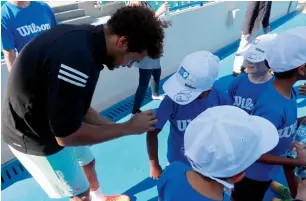  ?? Photo by Ryan Lim ?? French superstar Jo Wilfred Tsonga signs autographs for kids during the draw at the Internatio­nal Tennis Centre in Zayed Sports City on Monday. —