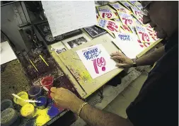  ?? DarenCalab­rese/Natio nal Post ?? Wayne Reuben paints price signs in a second-floor
workshop at Honest Ed’s on Bloor Street.