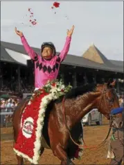  ??  ?? Jockey Mike Smith throws up roses from the Travers Stakes blanket that adorns West Coast, the winner of the 148th Travers Stakes at Saratoga Race Course.