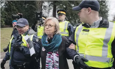  ??  ?? Federal Green Party Leader Elizabeth May is arrested by RCMP officers after joining protesters outside a Trans Mountain site in Burnaby on March 23.