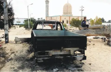  ?? Tarek Samy / Associated Press ?? A burned truck outside Al-Rawdah mosque in northern Sinai, Egypt, after the deadly terror attack.