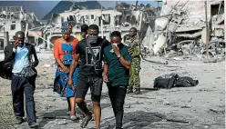  ?? AP ?? People walk away from the site of an explosion that hit Nigeria’s commercial capital of Lagos.