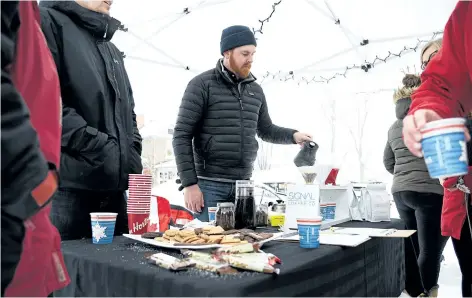  ?? CHERYL CLOCK/STANDARD STAFF ?? Coffee is served on a snowy Edmond Street Saturday morning, hosted by the Fitzgerald Neighbours. The group of community-conscious neighbours was raising funds for its team in the Coldest Night of the Year, a fundraiser for Start Me Up Niagara. Matt...
