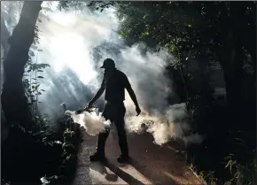  ?? GASTON DE CARDENAS/MIAMI HERALD ?? Fran Middlebroo­ks, a grounds keeper at Pinecrest Gardens, former home of the historic Parrot Jungle, uses a blower to spray pesticide to kill mosquitoes as Miami Dade county fights to control the Zika virus outbreak on Aug. 4 in Miami, Fla.