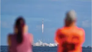  ?? Associated Press ?? ■ Julie and Doc Todd watch the launch of SpaceX from KARS Park in Florida, Monday. SpaceX launched 60 mini satellites, the second batch of an orbiting network meant to provide global internet coverage.