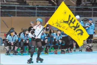  ??  ?? BallaReam Ya Barbie flies the Deadly Kennedys flag during the skater introducti­ons at Assassinat­ion City Roller Derby in Dallas.