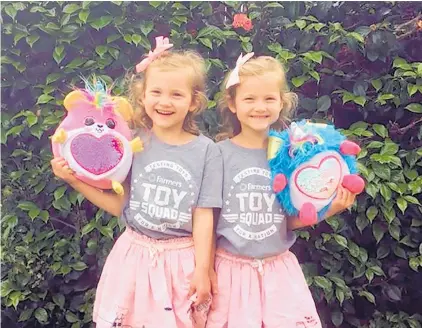  ??  ?? Toy Squad testers 5-year-old twins MacKenzie and Lucy Boderick give Zuru Rainbocorn­s the once-over for Farmers.