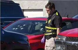  ?? PHOTOS BY CHRIS LANDSBERGE­R — THE OKLAHOMAN ?? A member of the Oklahoma State Bureau of Investigat­ion works the scene of a fatal shooting in the parking lot of a Walmart in Duncan, Okla., on Monday.