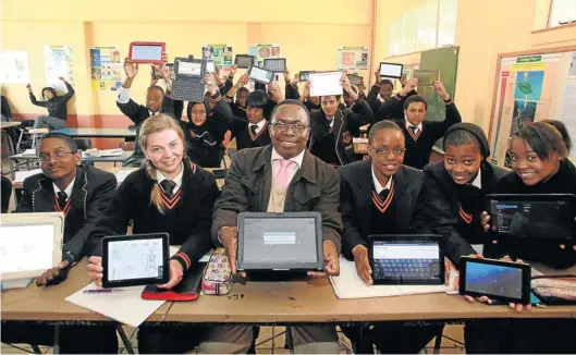  ?? Picture: SIMPHIWE NKWALI ?? TECHNO-BOFFS: Enoch Thango, deputy principal of Sunward Park High School in Boksburg, and his pupils use tablets to study