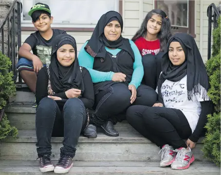  ?? DAX MELMER ?? Mariam Hasno, centre, fled the civil war in Syria and abuse from her husband for a better life in Windsor with her children, clockwise from top left, Sobhi, 10, Aya, 12, Zainab, 14, and Riham, 13.