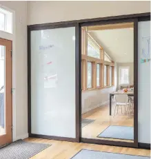  ?? STEVE RINGMAN, SEATTLE TIMES ?? Ellen Weiss added 1,000 square feet to her family’s 1954 home without changing the front facade. Right, kids can draw on giant sliding doors.