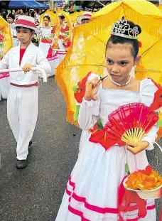  ??  ?? Jedna krásnější než druhá Slečna s oranžovým paraplíčke­m na snímku nahoře je z průvodu svátku Sinulog, dívka na snímku vpravo nahoře zase slaví Ati Atihan, stejně jako tanečníci v modrém (vpravo).