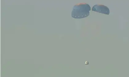  ?? ?? The uncrewed NS-23 capsule parachutin­g onto the desert floor after launch failure. Photograph: AP