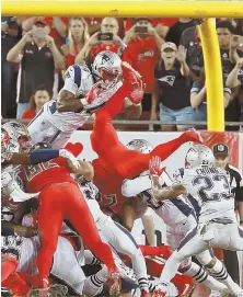  ?? StAff pHoto by MAtt StoNE ?? ALL-OUT EFFORT: The Patriots defense is unable to stop Buccaneers running back Doug Martin from flipping into the end zone for a touchdown last night.