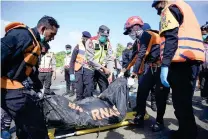  ?? AFP PHOTO ?? LOST LIFE
Members of Indonesia’s National Search and Rescue Agency carry a body bag during their search for missing Rohingya refugees near Calang, West Aceh on Saturday, March 23, 2024, two days after 69 such refugees were rescued from their capsized boat.